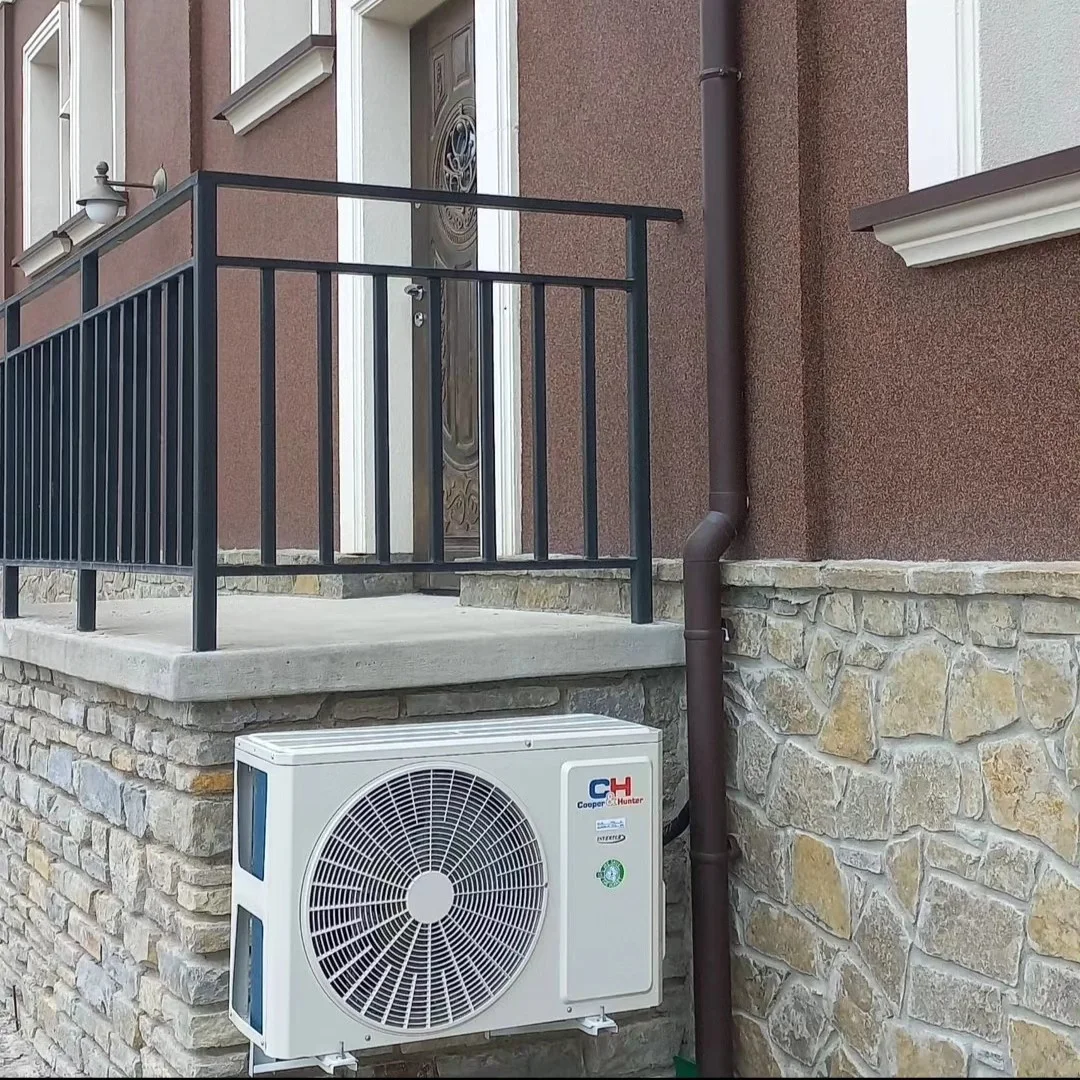 Зовнішній блок C&H під кованим ґанком котеджу — Професійний монтаж кондиціонерів у Кам’янці-Подільському